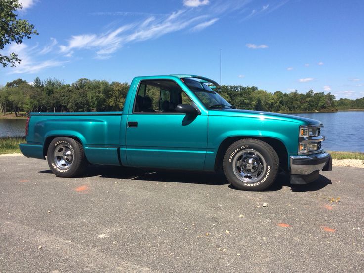 a bright blue truck is parked by the water