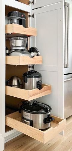 an open cabinet with pots and pans in it