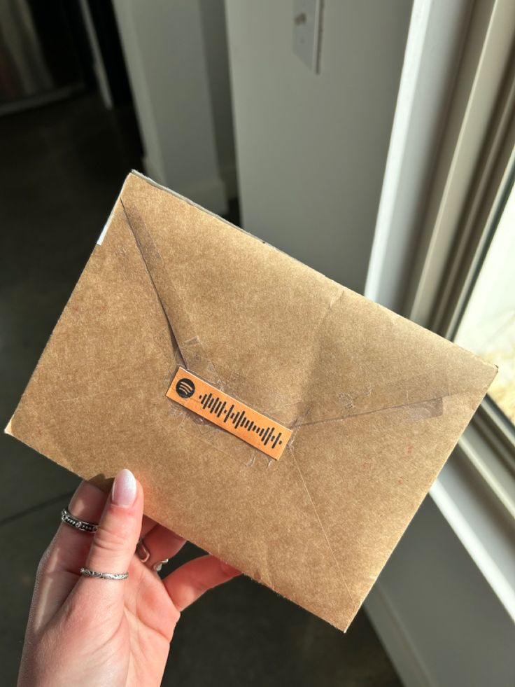 a person holding an envelope with a sticker on it