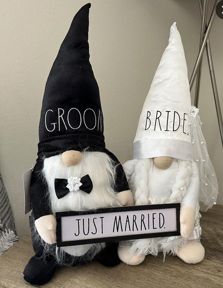 two gnomes dressed up as bride and groom sitting next to each other on a table