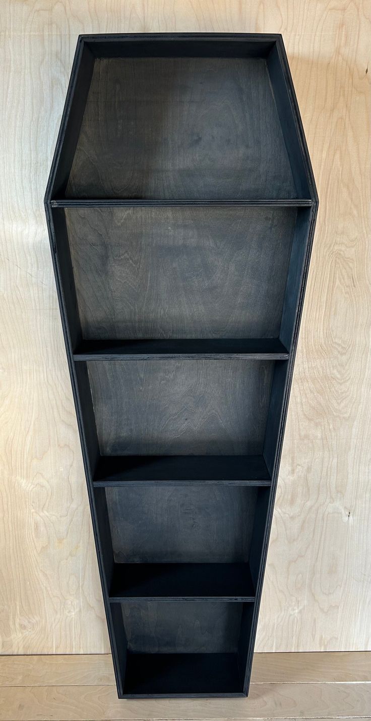 a black shelf sitting on top of a wooden floor