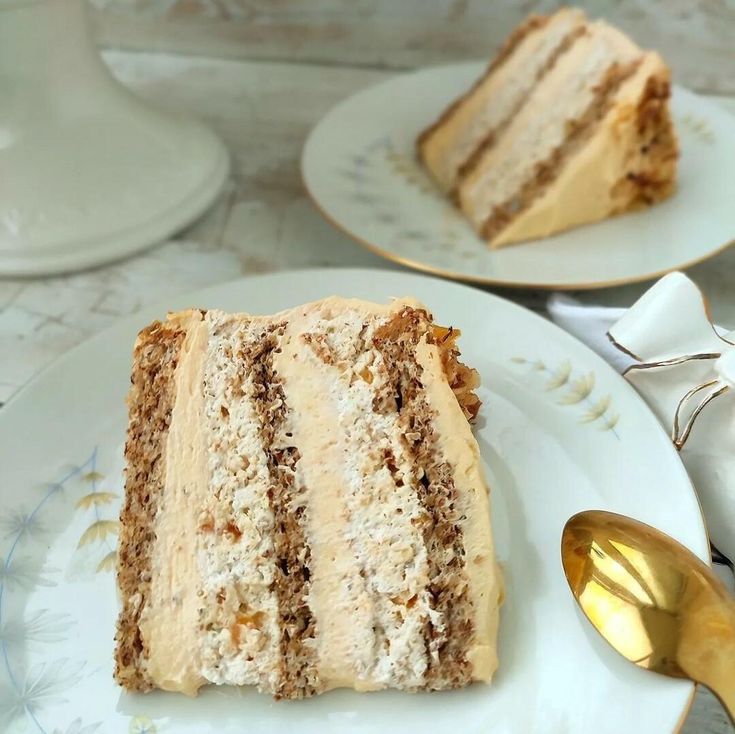 there is a piece of cake on the plate with gold spoons next to it