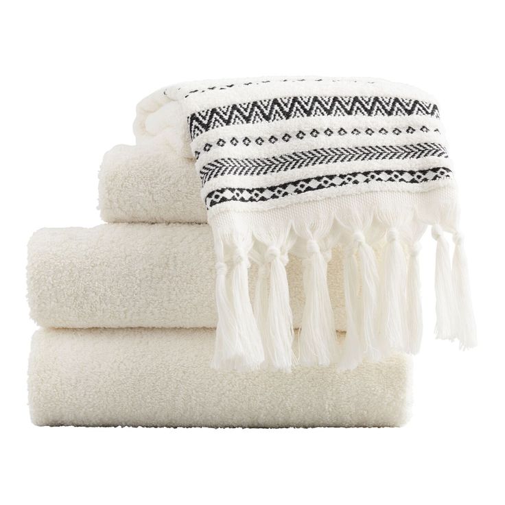 towels stacked on top of each other with tasselled ends and fringes around the edges