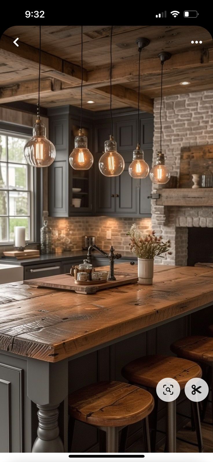 a kitchen island with stools and lights hanging from it's ceiling in front of an oven