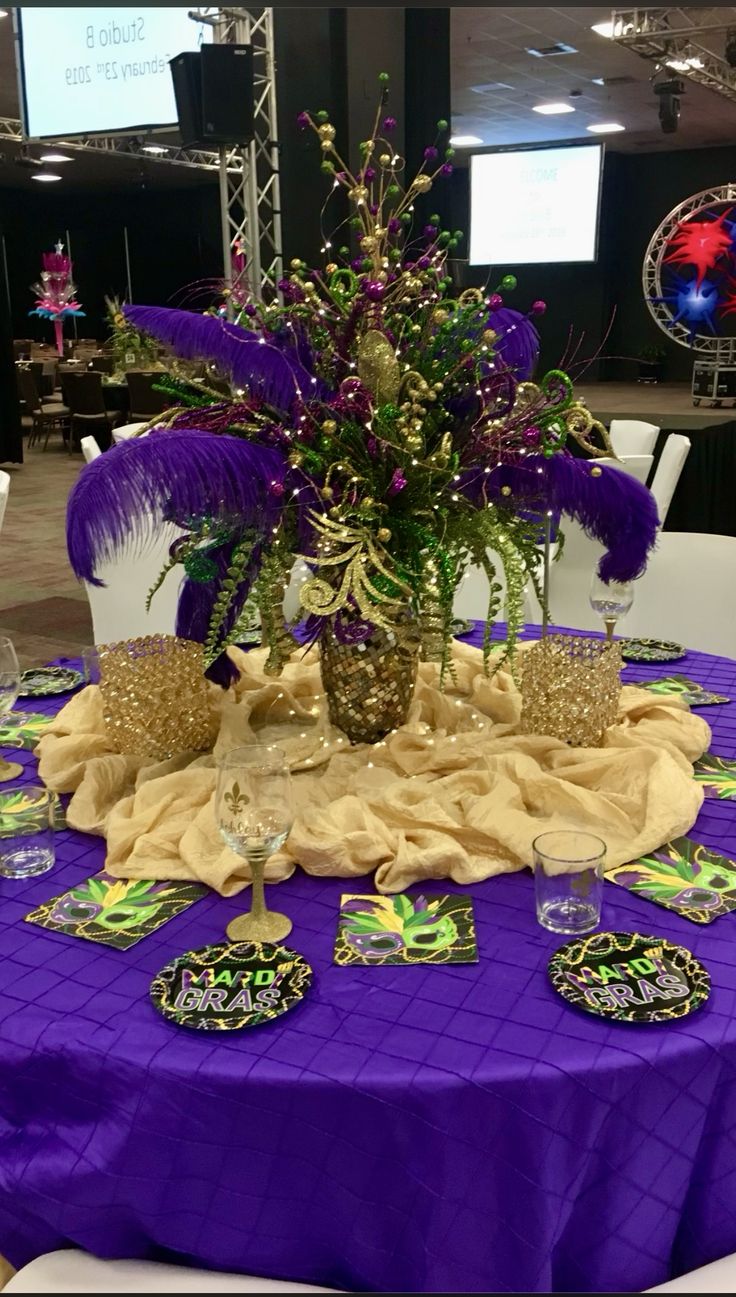 a purple table cloth topped with a vase filled with flowers