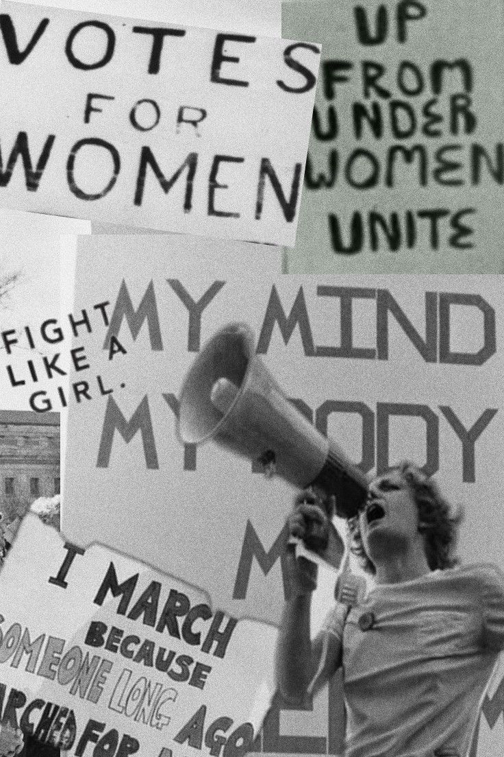 a woman speaking into a megaphone surrounded by protest signs