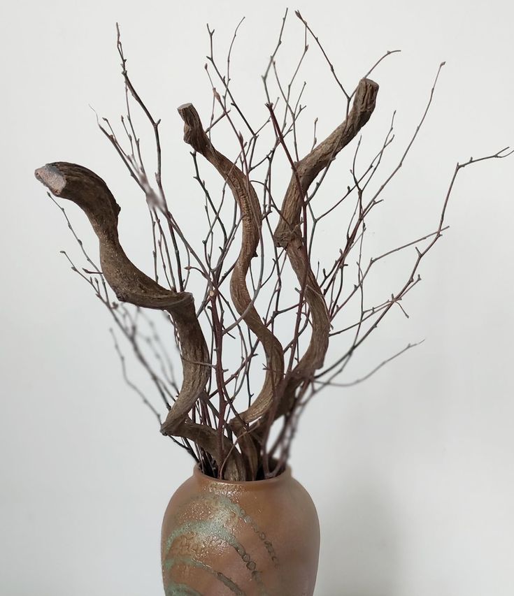 a vase filled with branches on top of a table