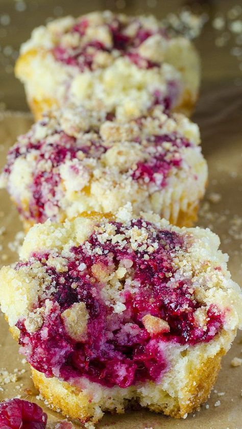 two raspberry muffins sitting on top of a table