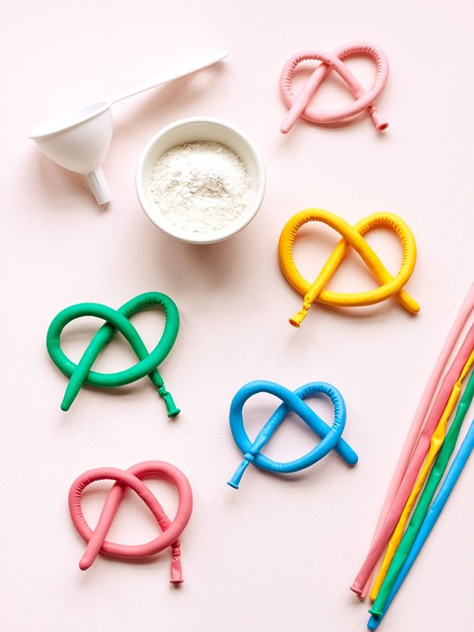 several different colored objects on a white surface next to some straws and spoons