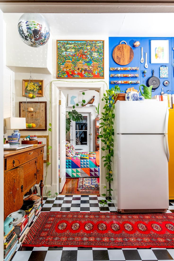 a kitchen area with a refrigerator, cabinets and pictures on the wall above it's doorway