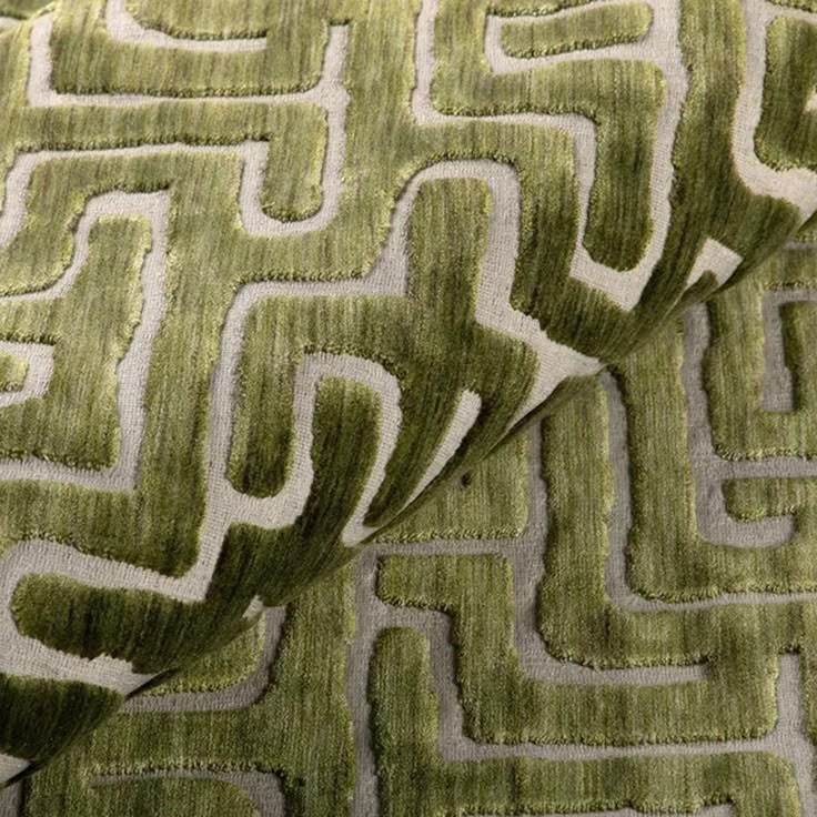 a close up view of a green and white fabric with an interesting design on it