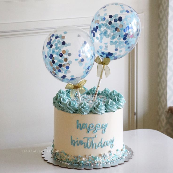 a birthday cake with two balloons on top