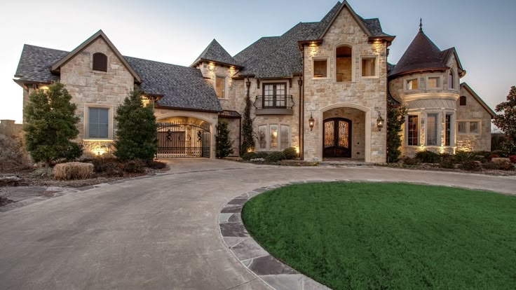 a large stone house with lots of windows and grass in front of the entrance to it