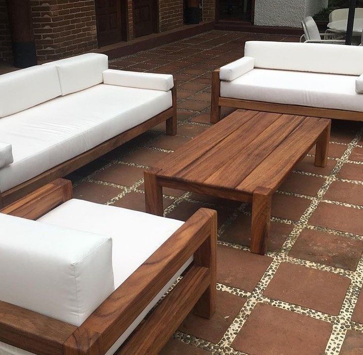 some white couches sitting on top of a brick floor