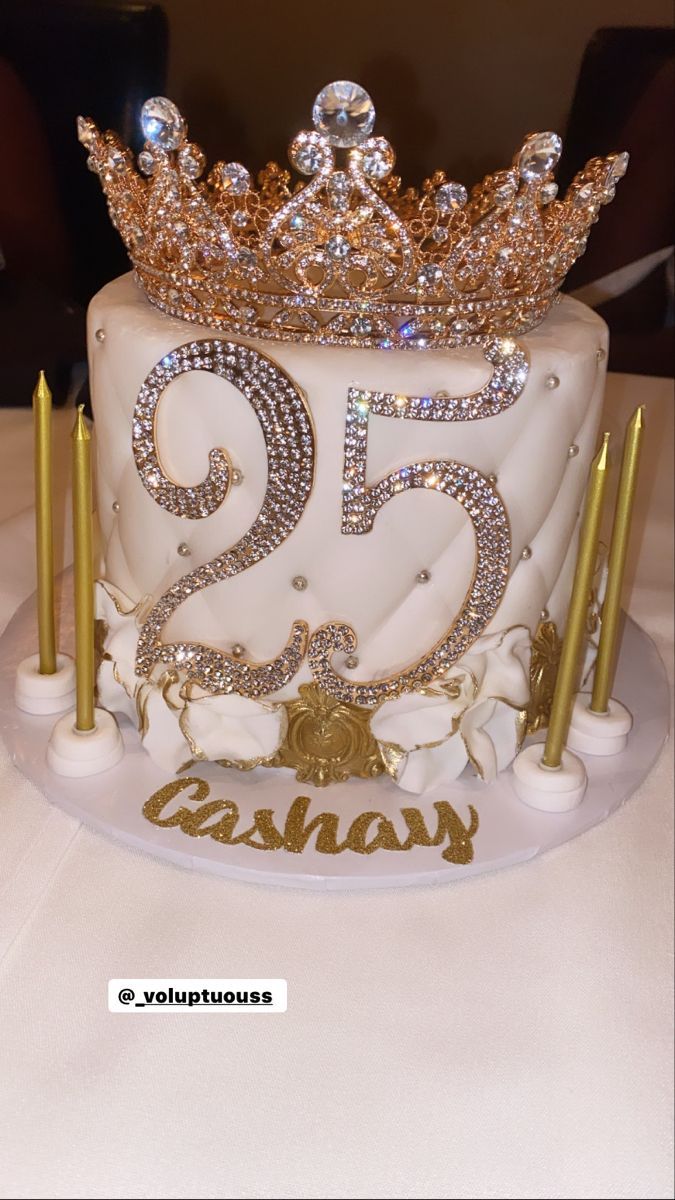 a white cake with gold decorations and candles