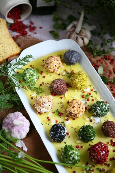 a white dish filled with food next to bread and flowers on a wooden cutting board