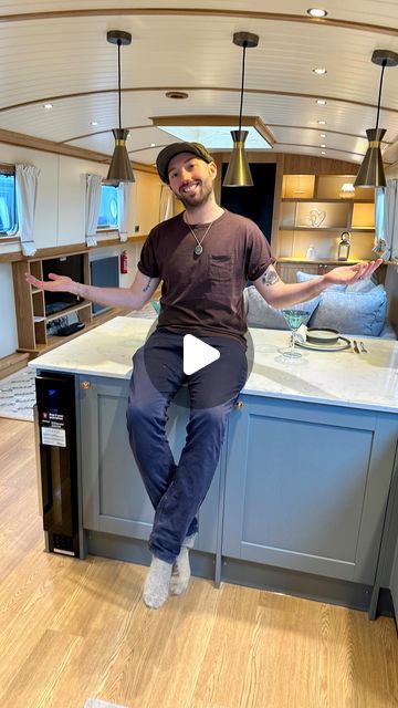 a man sitting on top of a kitchen counter