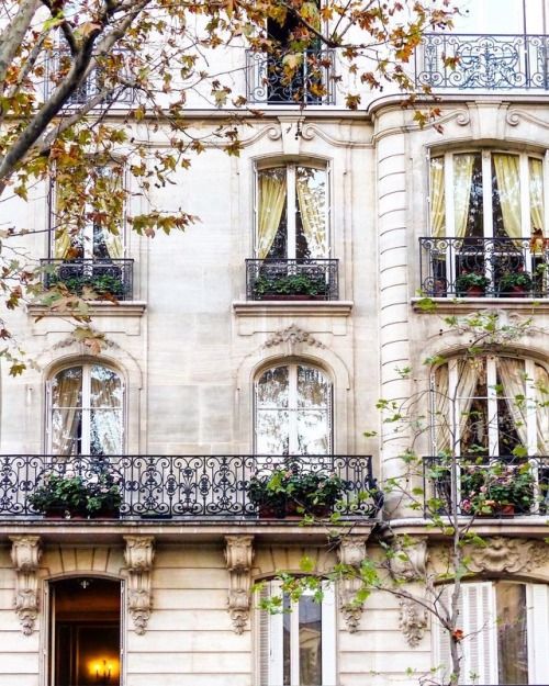 an apartment building with balconies and flowers in the window boxes on the balcony