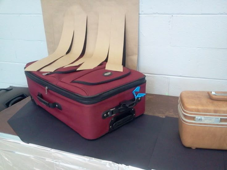 two pieces of luggage sitting on top of a table next to another piece of luggage