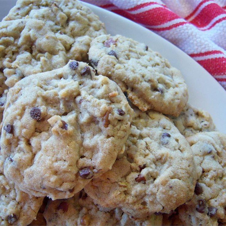 a white plate topped with cookies on top of a red and white table cloth next to a glass of milk