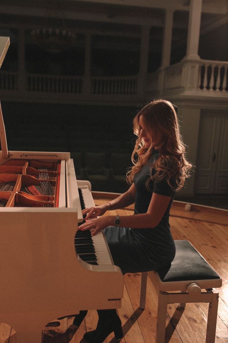 a woman sitting at a piano in a room