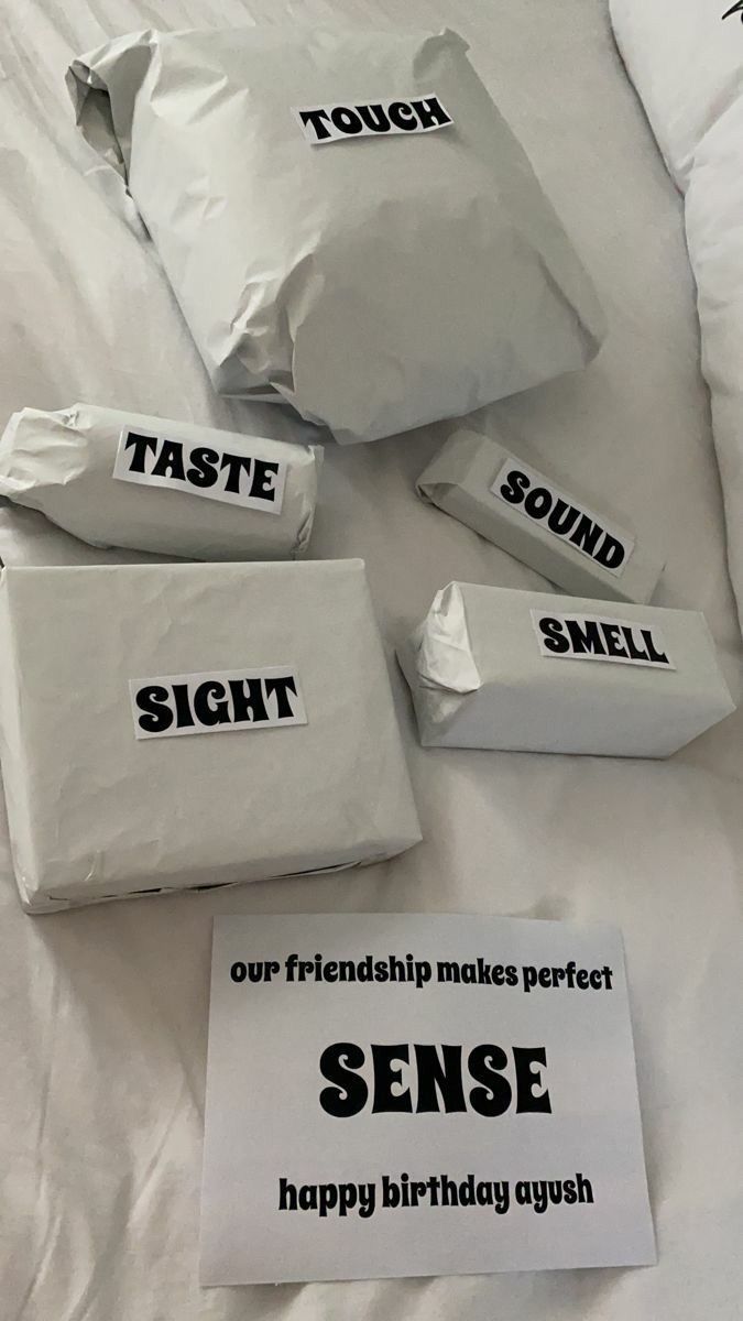 four bags of food sitting on top of a white bed with the words taste, sound and smell printed on them