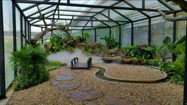 the inside of a glass house with plants and rocks in the ground, steam coming out