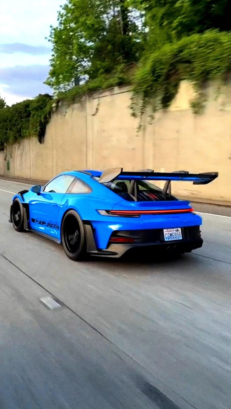 a blue sports car driving down the road