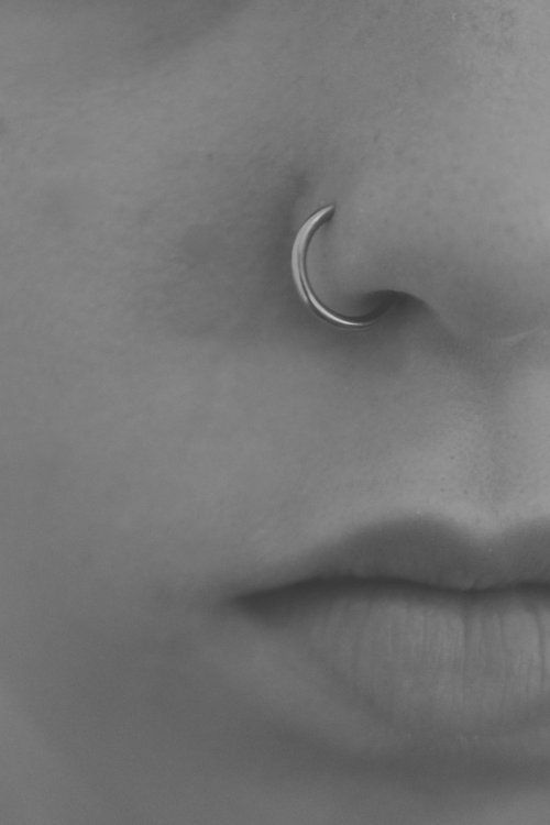 a woman's nose with a crescent shaped nose ring on top of her nose