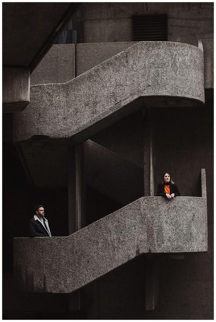 two people standing on the balcony of an apartment building