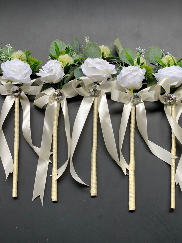 wedding bouquets with ribbons and flowers on the back side are arranged in a row