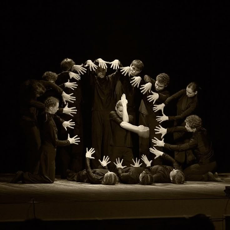 a group of people standing on top of a stage with their hands in the air