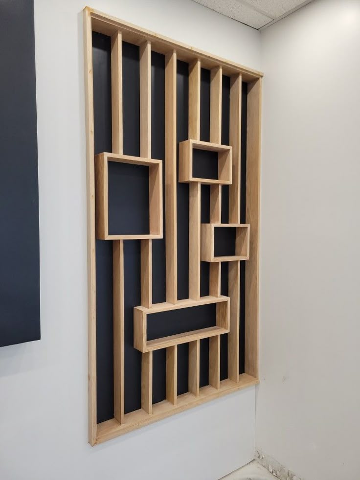 a wooden shelf sitting on top of a white wall next to a black and white painting