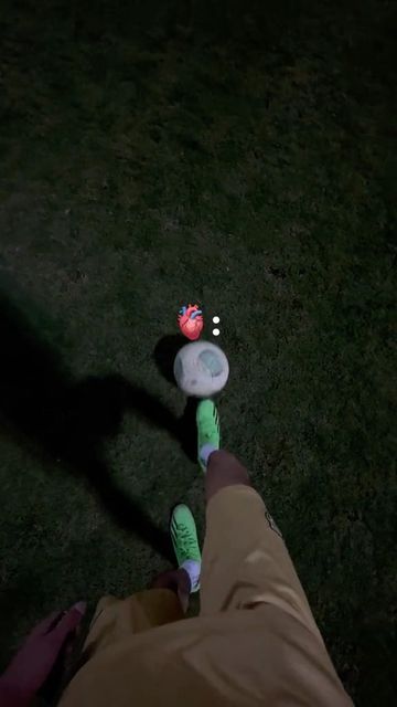 a person standing in the grass with their foot on a frisbee at night