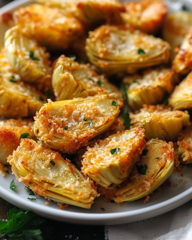 some artichokes on a white plate with parmesan cheese