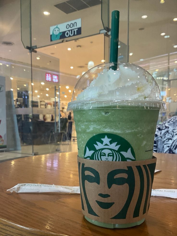 a starbucks drink sitting on top of a wooden table