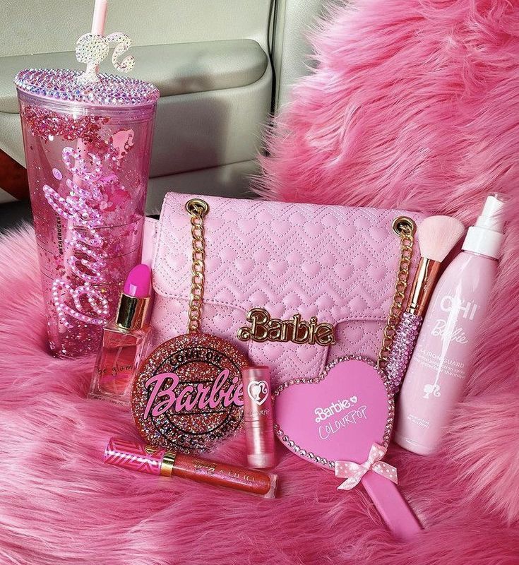 the contents of a pink purse, lipstick, and other items are laid out on a furry surface