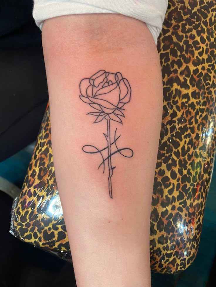 a woman's arm with a rose tattoo on the left side of her body