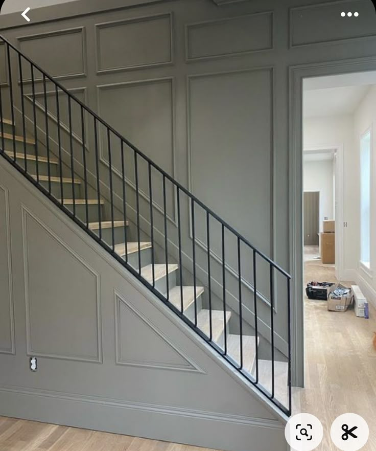 an empty room with stairs and hard wood flooring