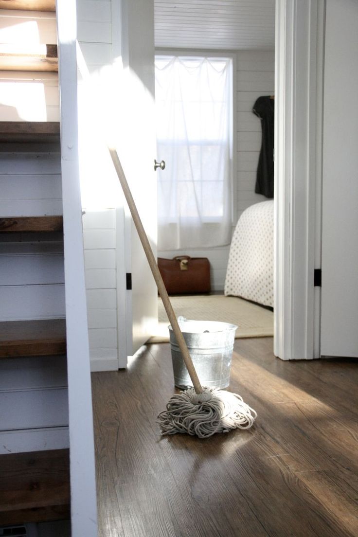 a mop is sitting on the floor next to a bucket