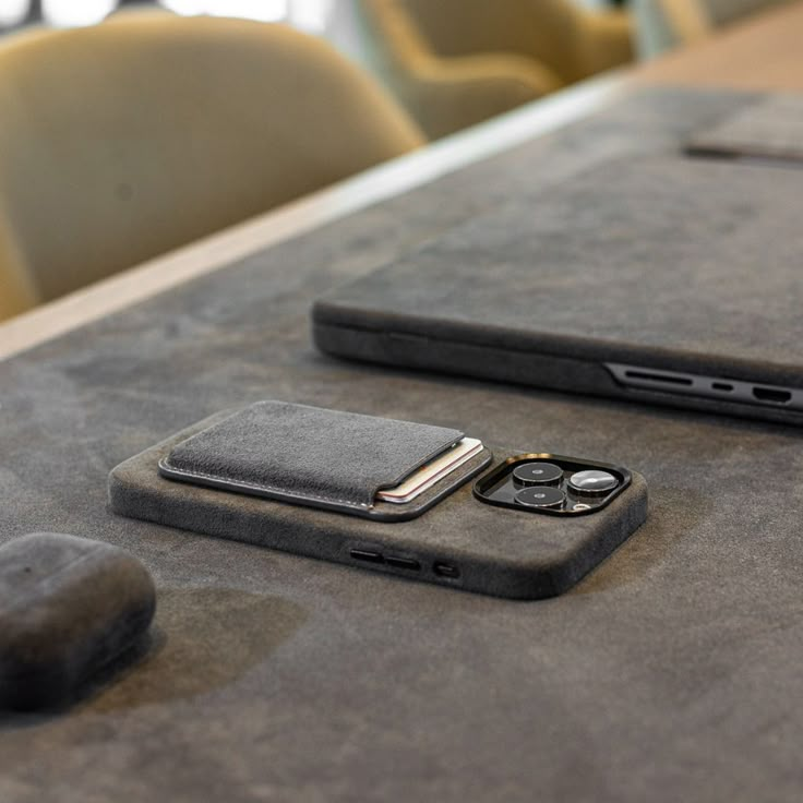 two cell phones sitting on top of a table next to each other, one is black