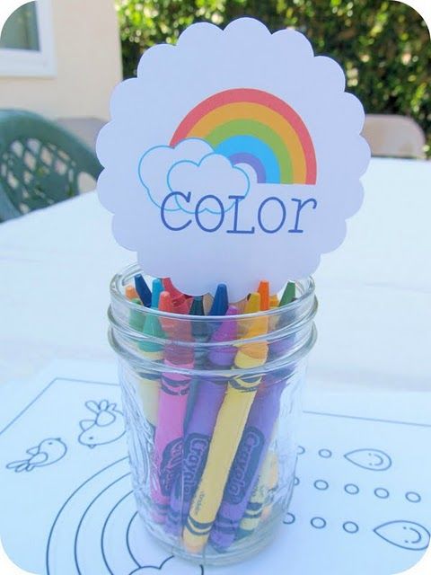 a jar filled with crayons sitting on top of a table next to a sign that says color