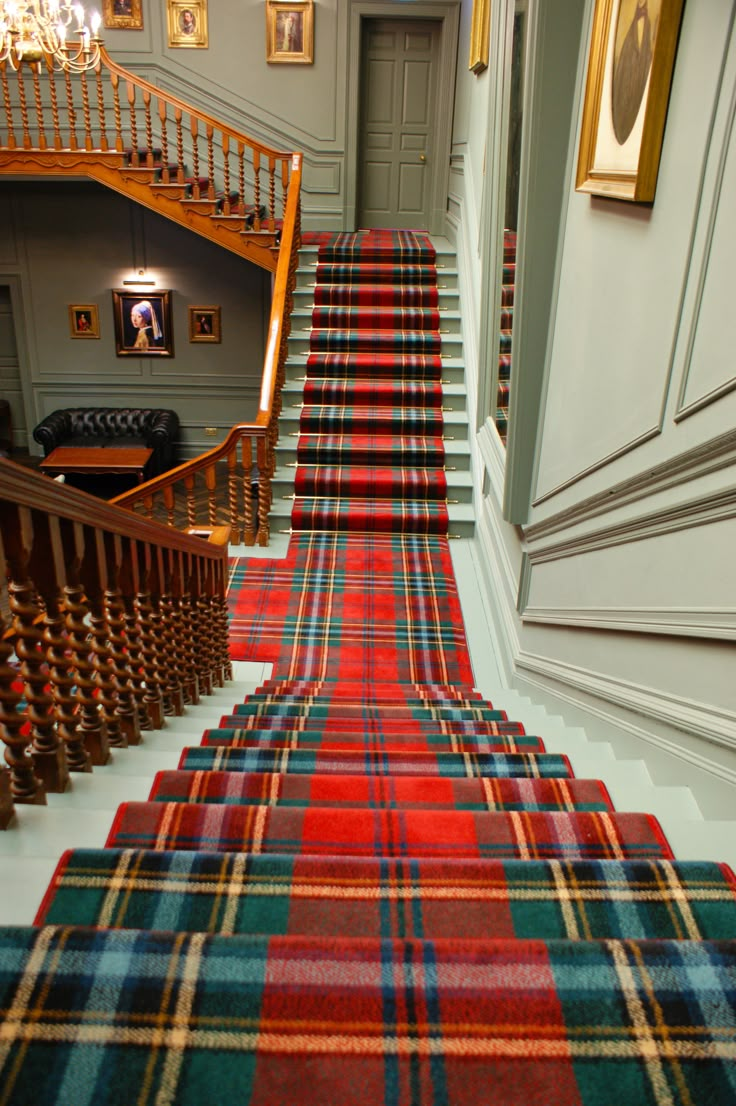 a red carpeted staircase leading up to the first floor