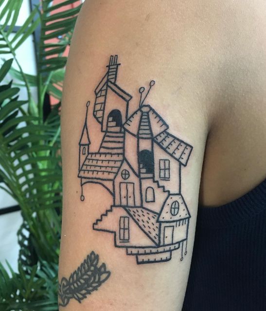 a woman with a tattoo on her arm that has a house and trees in it