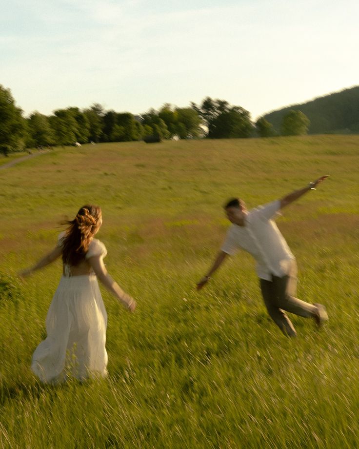 a man and woman are running through a field