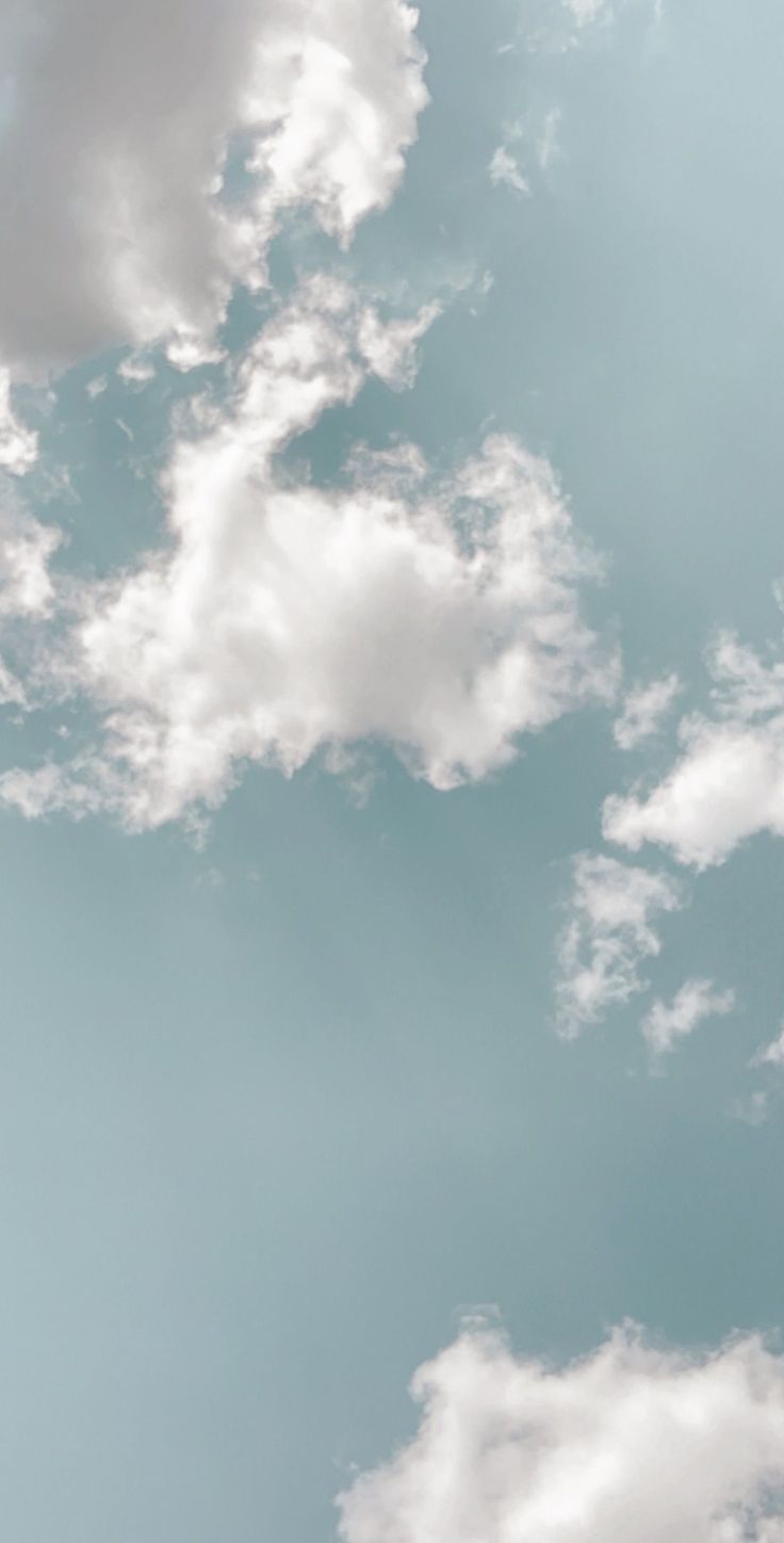 an airplane flying in the sky with clouds