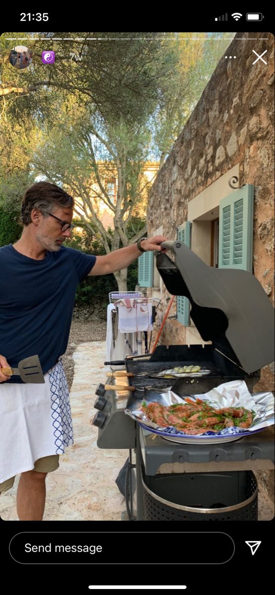 a man standing next to an open grill with food on it