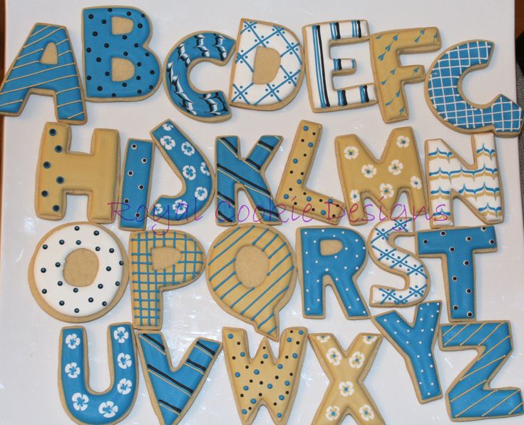 the cookie letters are decorated with blue and white icing