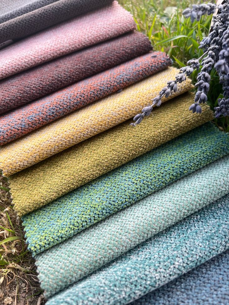 a stack of towels sitting next to each other on top of a grass covered field