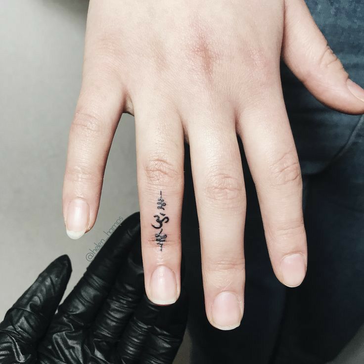 a person with a small tattoo on their ring finger